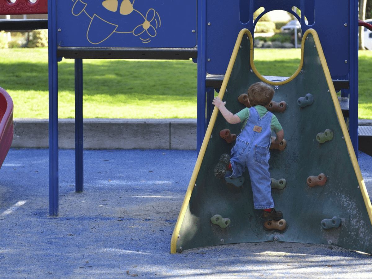 kid playing in rock climbing slide